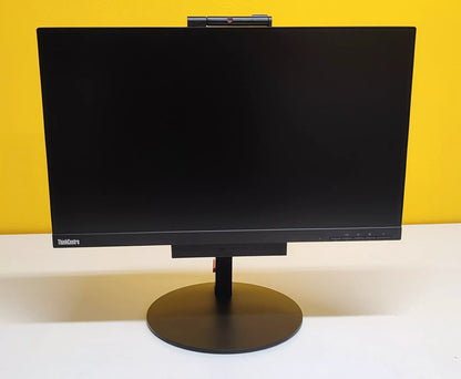 Lenovo ThinkCentre TIO24 All-in-One spento su sfondo giallo, con design elegante e base circolare stabile per scrivanie moderne.