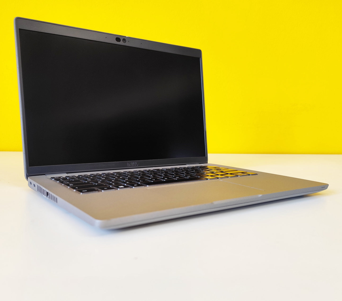 Dell Latitude 5420 acceso su sfondo giallo, notebook ricondizionato con tastiera italiana e display FHD da 14”.