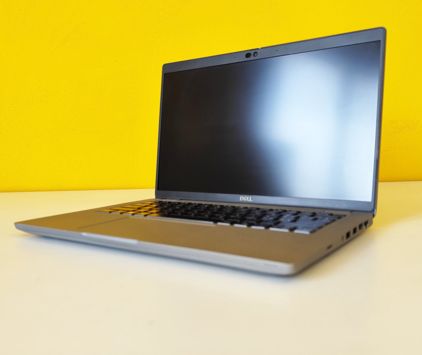 Notebook Dell Latitude 5420 acceso, vista angolata su sfondo giallo, ideale per lavoro e studio in mobilità.